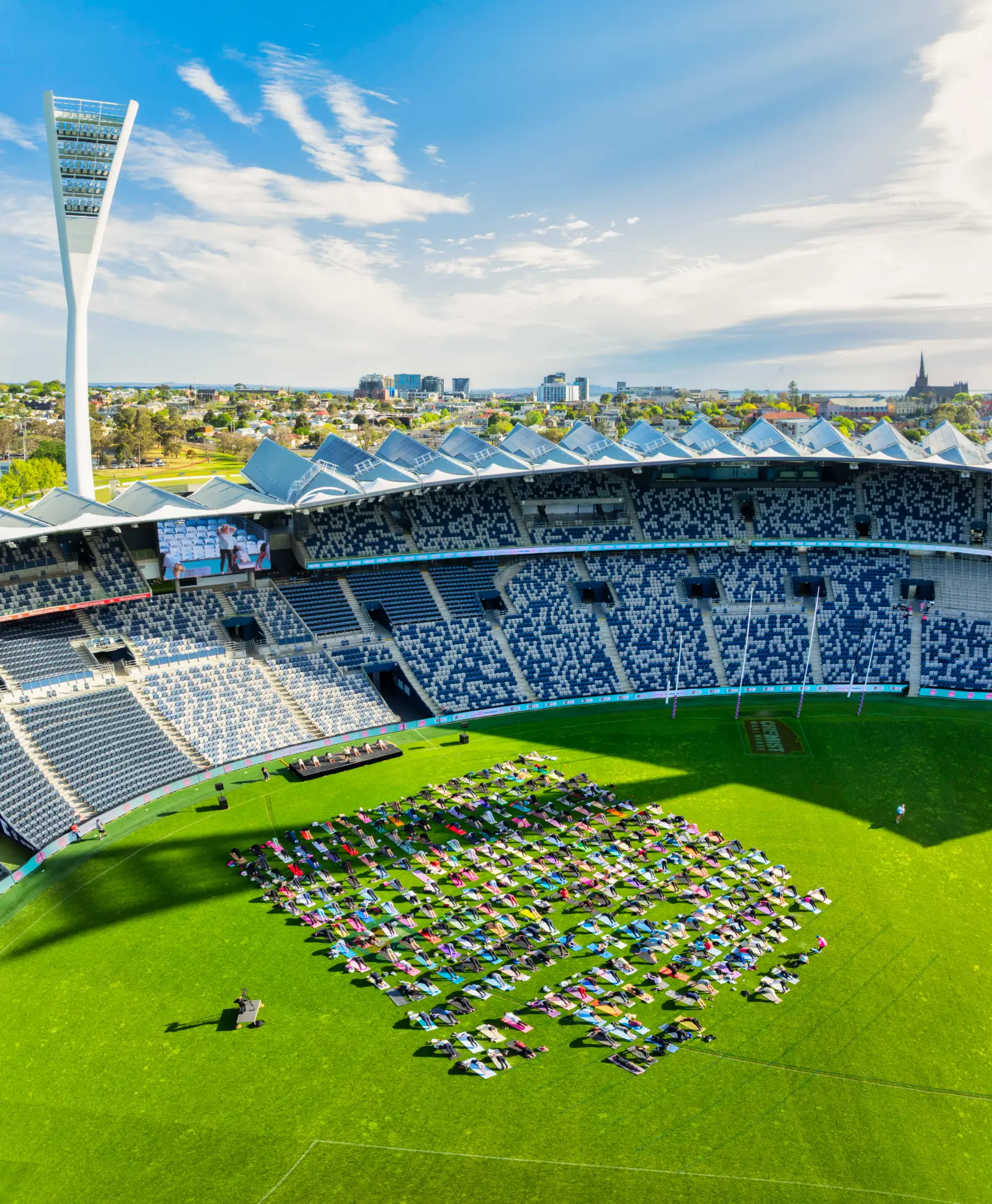 Hundreds of people on their mats across the oval at GMHBA Stadium